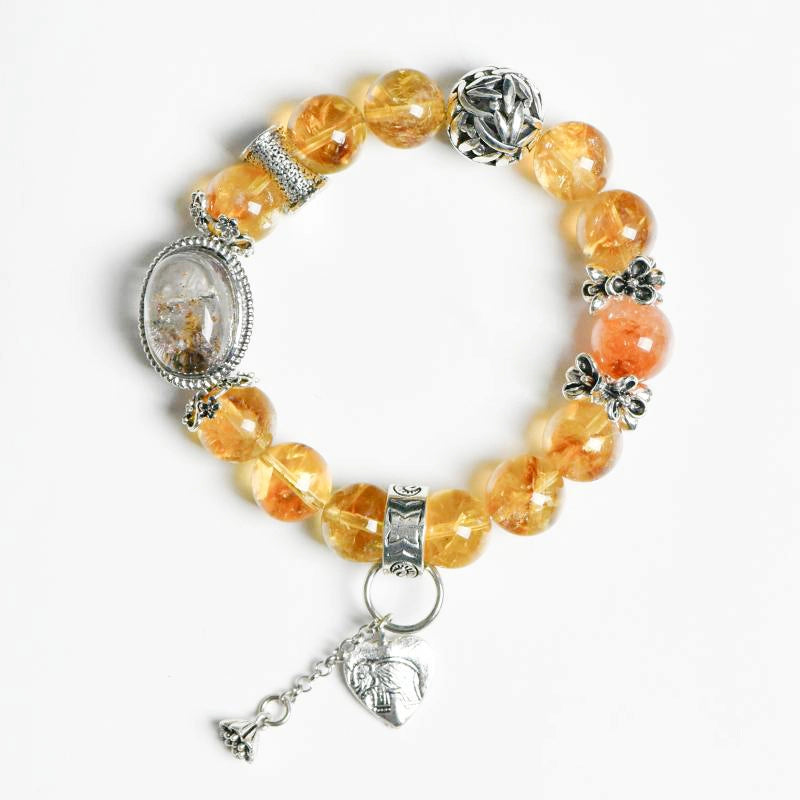 Roline’s Citrine Bracelet blends Citrine, Red Hematoid Quartz & silver accents for abundance & strength. 12mm beads. Shop mystical crystal jewelry now!