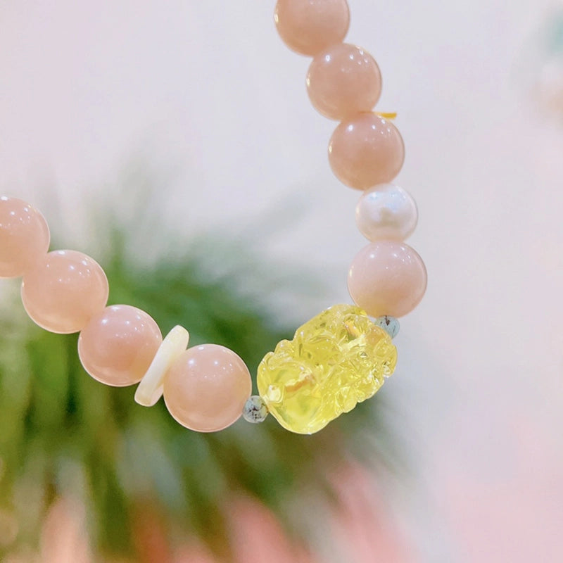 Sunstone bracelet with Amber Pixiu charm and golden beads by Roline Crystal